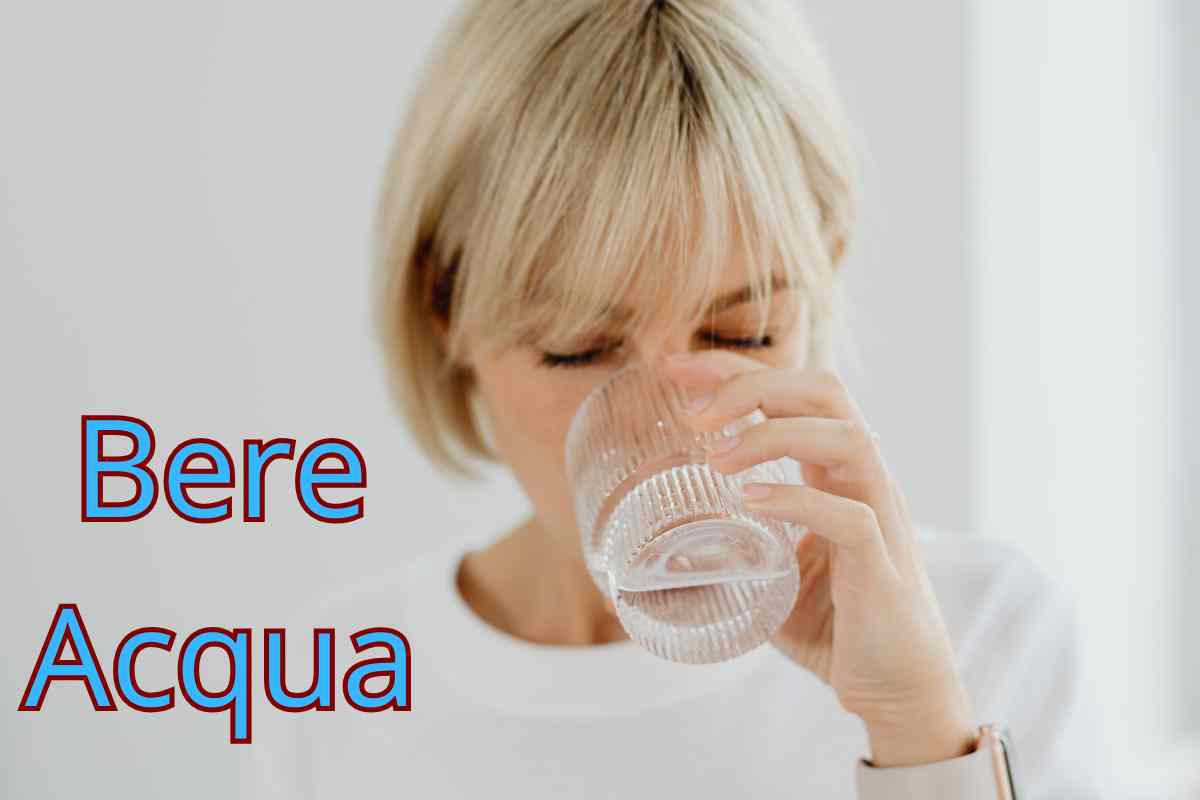 donna che beve un bicchiere d'acqua