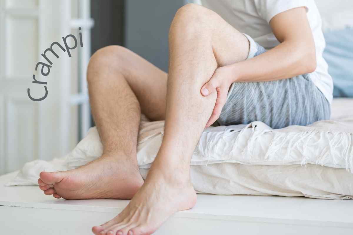 persona che si tiene una gambatra le mani per un crampo