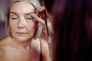 signora con la palpebra cadente che si sta truccando