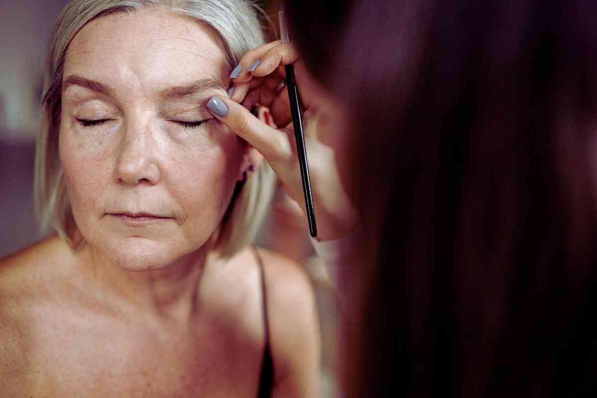 signora con la palpebra cadente che si sta truccando