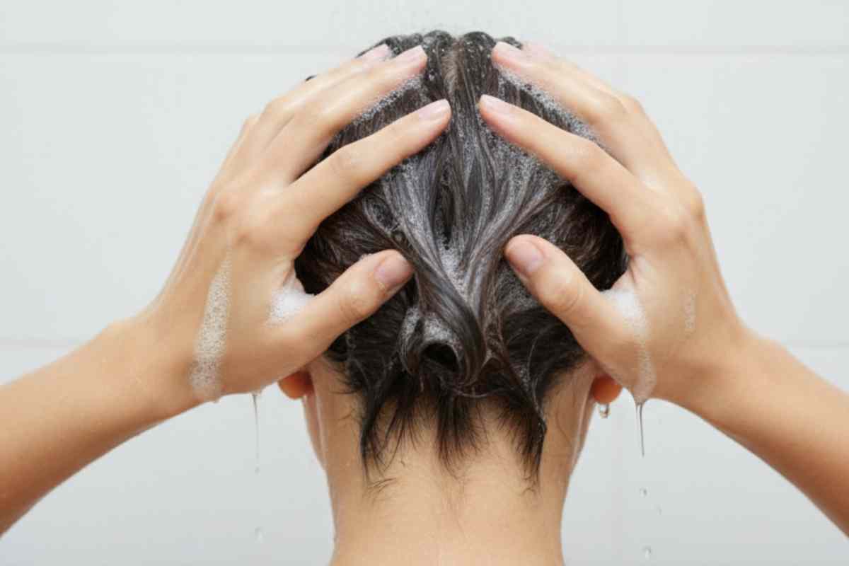 donna di spalle che si lava i capelli