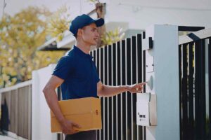 uomo con un pacco in mano che suona il campanello di casa